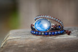 A triple wrap adjustable bracelet that features a large blue labradorite gemstone in sterling silver. 