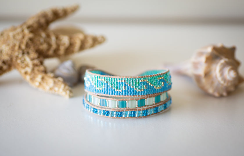 A handmade beaded triple wrap bracelet with a coastal wave beachy theme. 