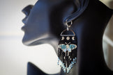 Beaded earring on a mannequin ear with a plain background