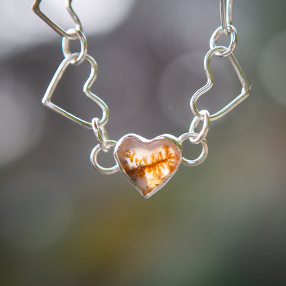 A dendritic heart shaped charm with heart shaped link bracelet in sterling silver.