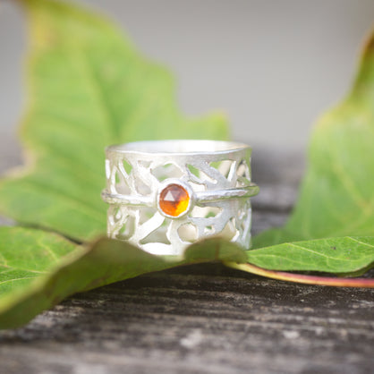 A hand-cut sterling silver spinner ring with a madeira citrine round gemstone. 