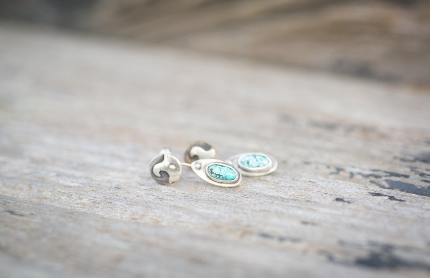 These handmade sterling silver and turquoise earrings are tiny! They feature a wave detail with a surfboard that dangles independently underneath. The surfboard has a natural turquoise stone. 