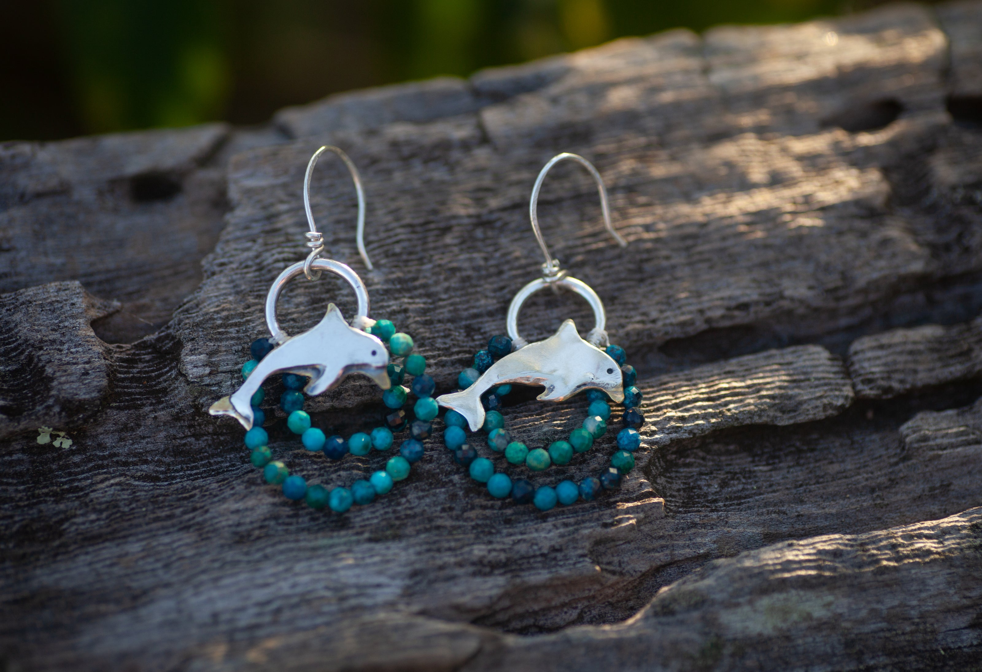 Dolphin earrings in sterling silver with beaded turquoise colored gemstones. 