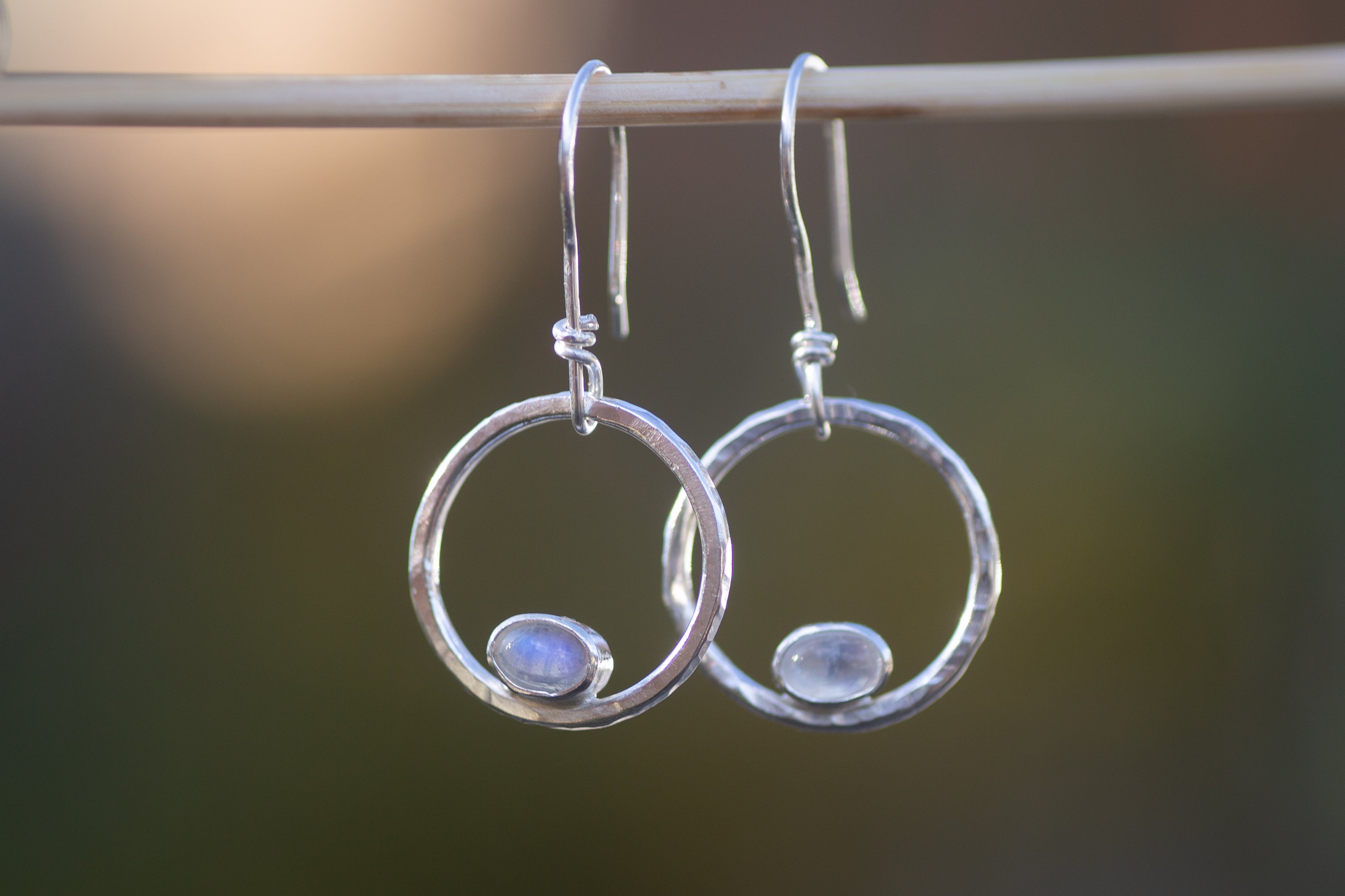 Earring hoops in sterling silver with tiny moonstone ovals. 